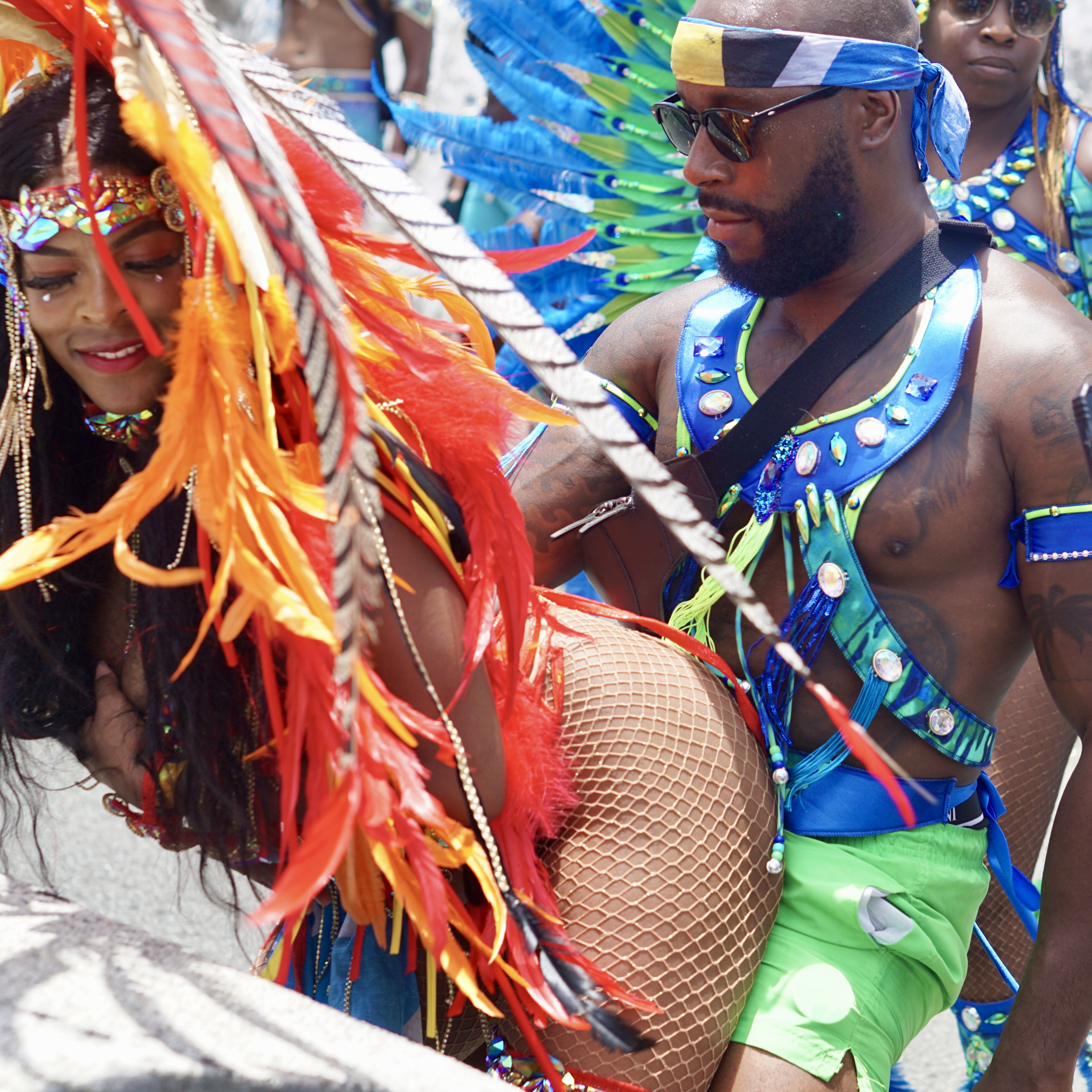 Man and woman decked out in their costumes dancing to soca