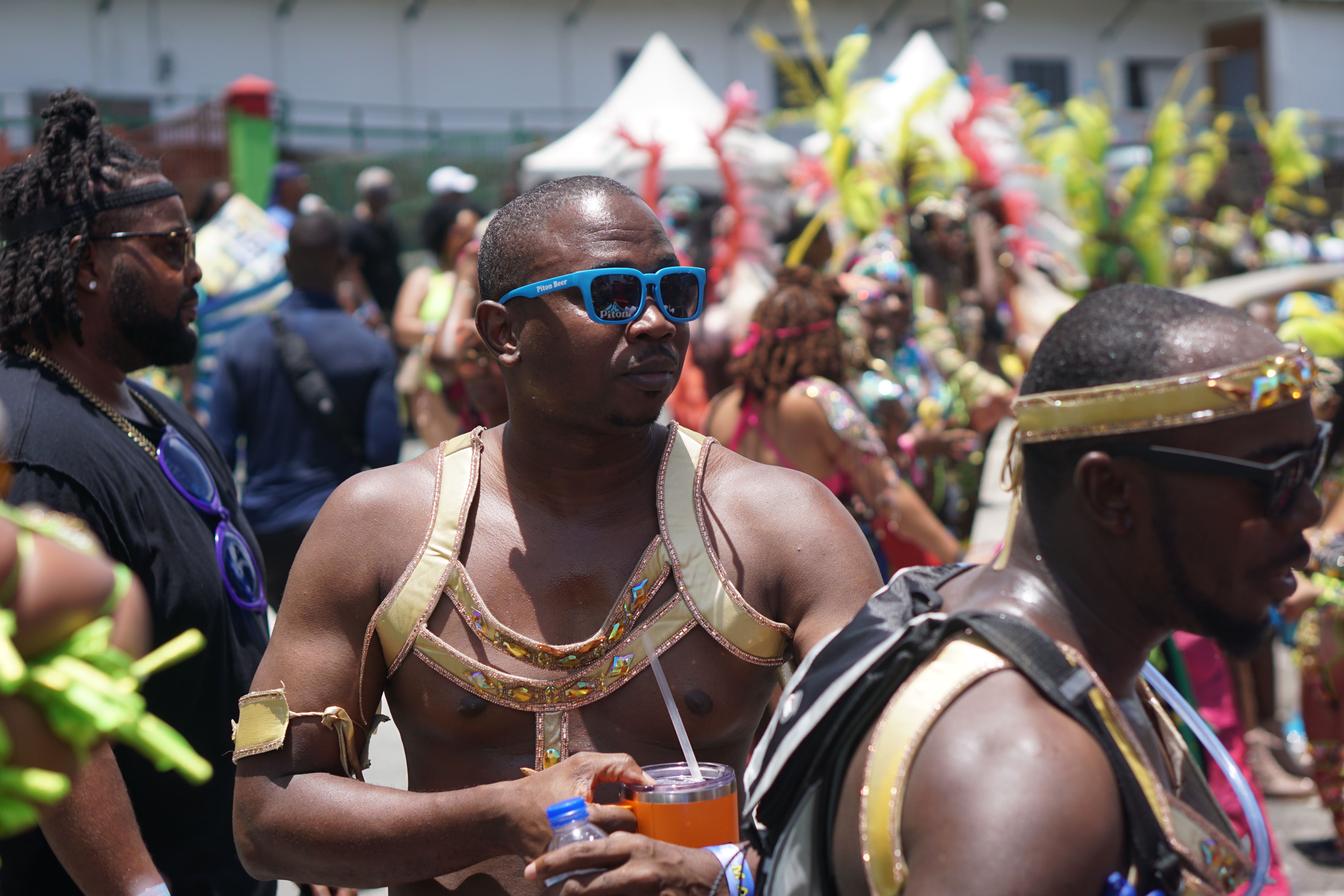 Man in his St lucia carnival costume in blue shades on enjoying the road.